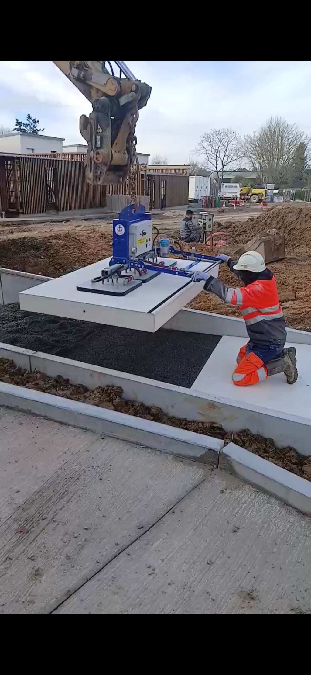 palonnier à ventouses à batterie posant une dalle béton lourde