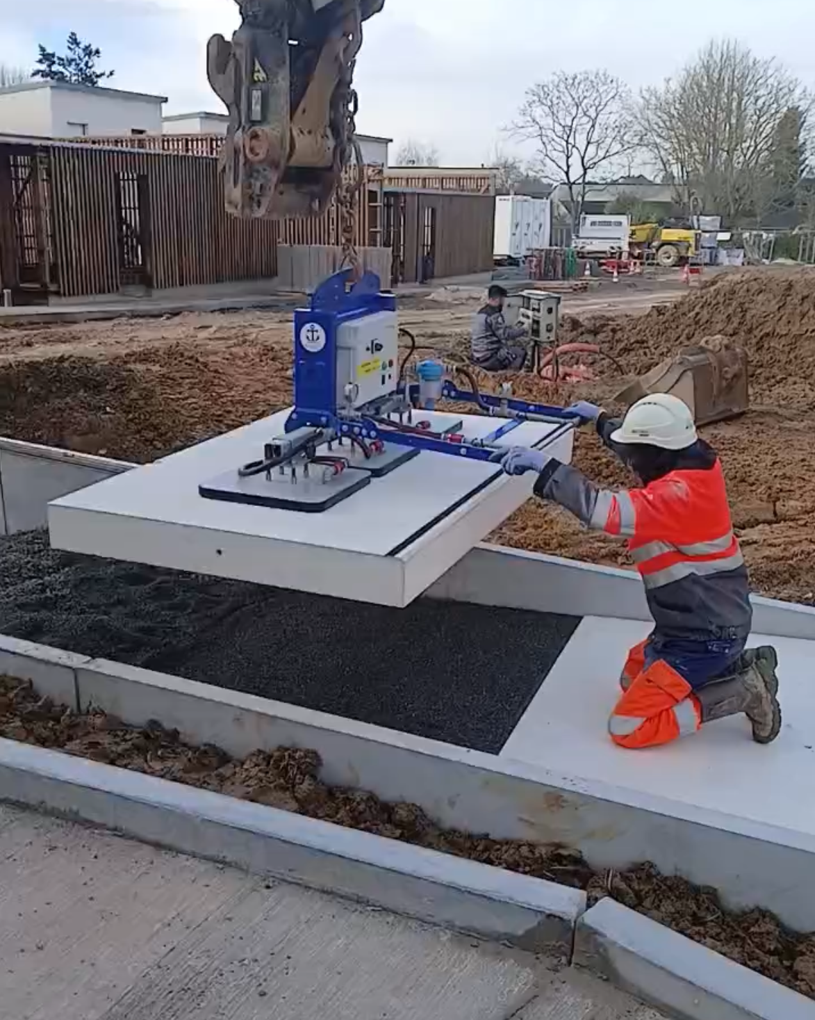palonnier à ventouses à batterie posant une dalle béton lourde